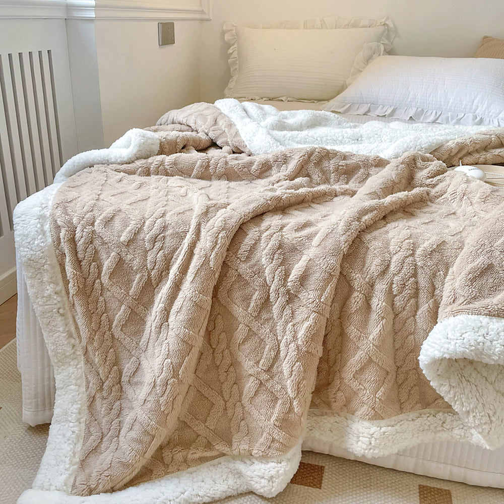Light Brown reversible sherpa throw blanket draped over a bed, textured plush side up