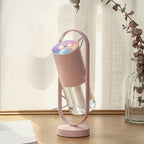 Pink humidifier with its light on, on a wooden table by a window