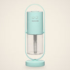 Light Blue mini USB humidifier in its oval stand with a clear water tank, front view