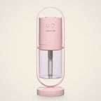 Pink mini USB humidifier in its oval stand with a clear water tank, front view