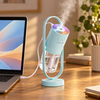 Light blue mini USB humidifier with its light on, powered by USB from a laptop