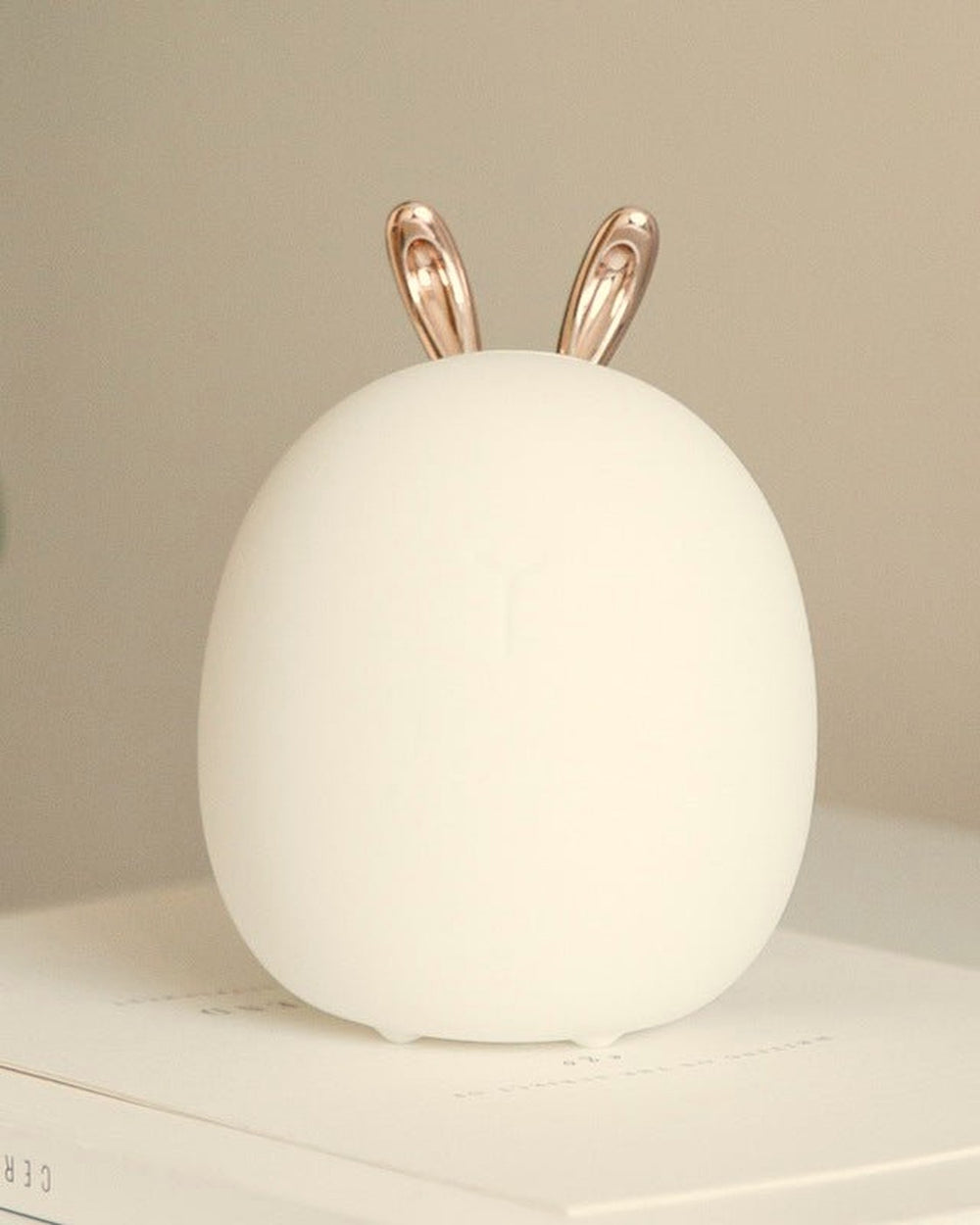 Mistglow bunny night light on a desk with books